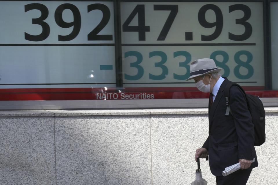 A person walks past an electronic stock board showing Japan's stock prices at a securities firm Thursday, April 11, 2024, in Tokyo. (AP Photo/Eugene Hoshiko)