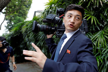 FILE PHOTO: A North Korean cameraman reacts as he is chased by media outside St Regis hotel, ahead of the summit between the North Korean leader Kim Jong Un and U.S. President Donald Trump, in Singapore June 10, 2018. REUTERS/Tyrone Siu/File Photo