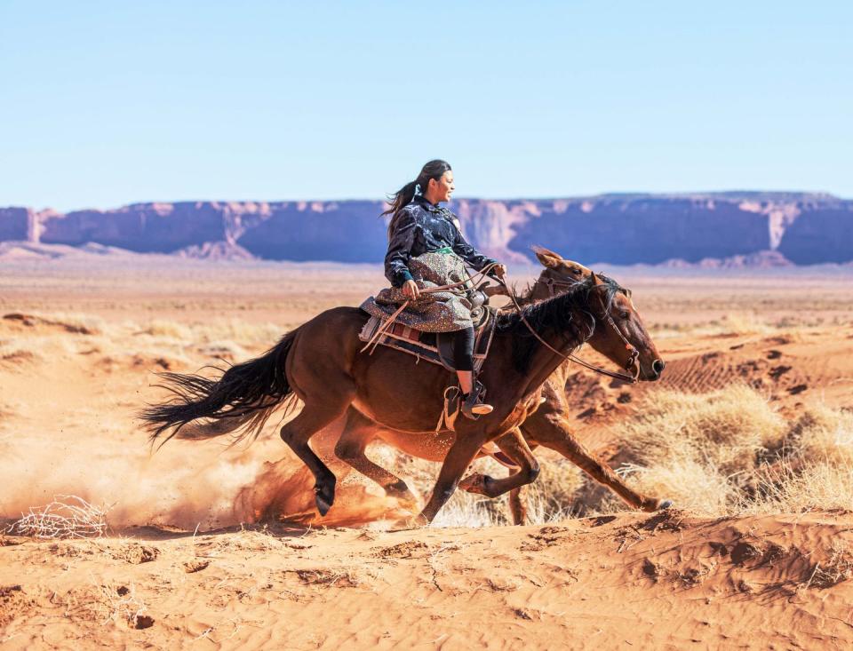 navajo sisters galloping on horses in arizona