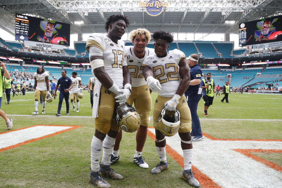 FILE - Saturday, Oct. 19, 2019 file photo, Georgia Tech defensive lineman Sylvain Yondjouen of Belgium (32) poses with linebacker Demetrius Knight II (17) and running back Jamious Griffin (22) after an NCAA college football game against Miami, in Miami Gardens, Fla. Football in Europe usually means "soccer." But increasingly European kids are excelling at American football. So much so that Europe has become a pipeline of recruits for college football programs — and increasingly for schools from the Power Five conferences. (AP Photo/Wilfredo Lee, file)