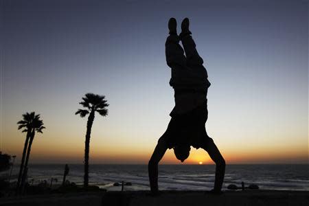 A youth practices parkour, also known as free-running, as he does a handstand at the seaside in the city of Netanya in this December 23, 2011 file photo. REUTERS/Amir Cohen/Files