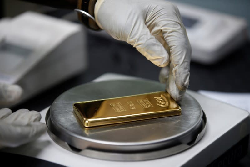 An employee weighs a 1kg gold bar at AGR (African Gold Refinery) in Entebbe