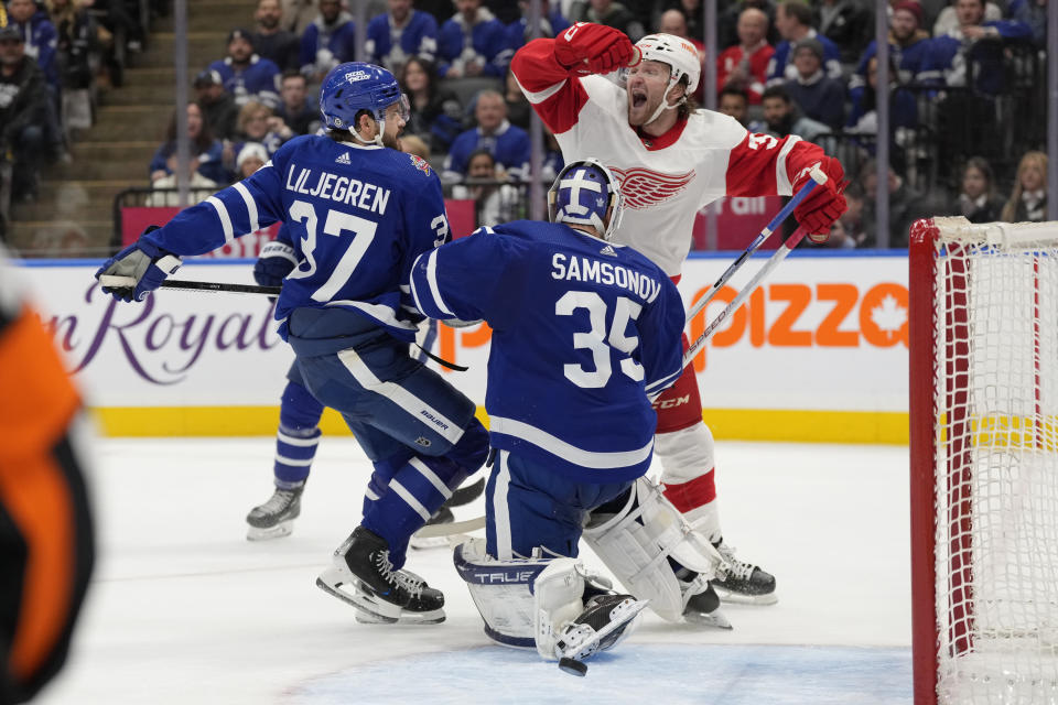 Detroit Red Wings right wing Christian Fischer, top right, celebrates a late go-ahead goal by teammate Lucas Raymond (not shown) as Toronto Maple Leafs goalie Ilya Samsonov (35) and Timothy Liljegren, left, react during third-period NHL hockey game action in Toronto, Sunday, Jan. 14, 2024. (Frank Gunn/The Canadian Press via AP)