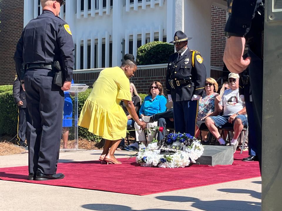 Family members and community leaders place roses on a memorial outside the Tallahassee Police Department headquarters, May 16, 2024.