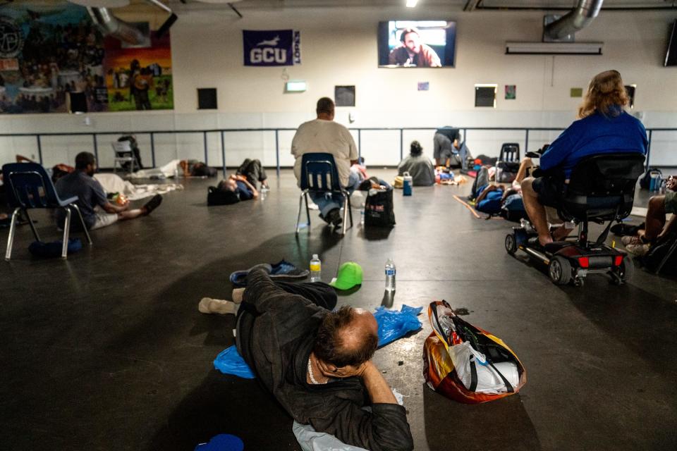 People cool off from the heat as they gather inside St. Vincent de Paul's dining room at the Human Services Campus in Phoenix on July 20, 2023.