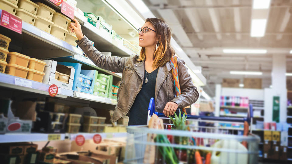 Shot of a young woman shopping at a grocery store.