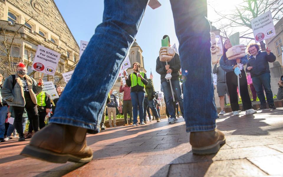 Demonstrators listen to Indiana University graduate student Timothy Biewer-Heisler speak April 14 at the Sample Gates in support of the graduate student workers' strike.