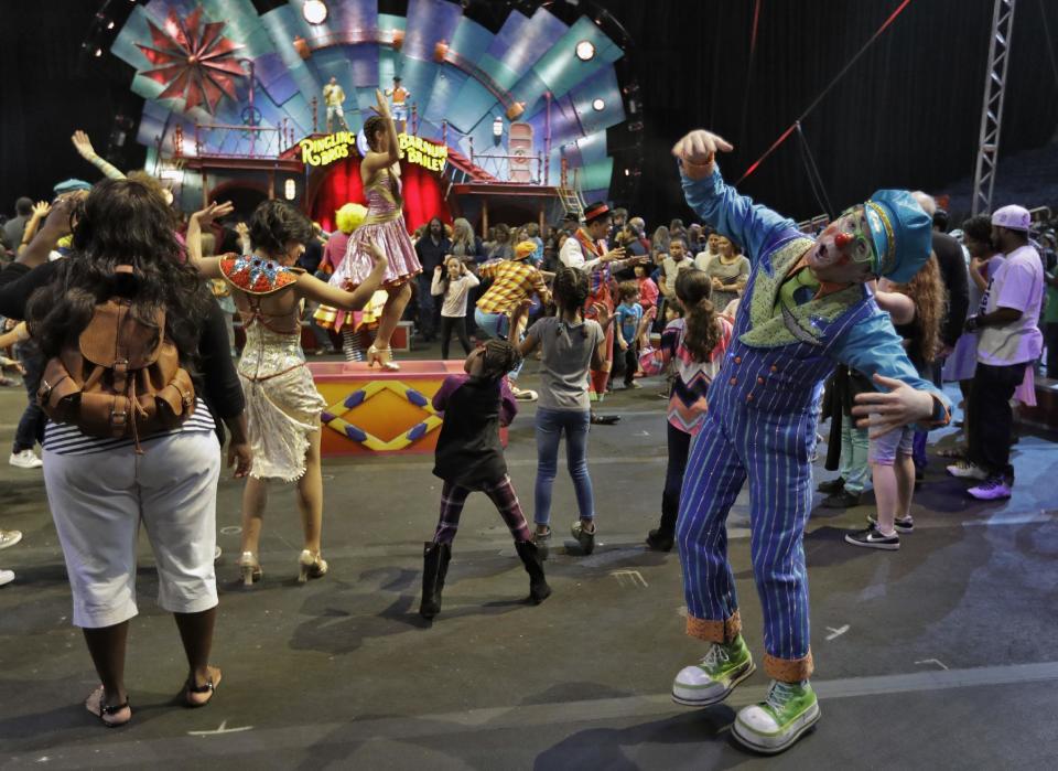 Ringling Bros. and Barnum & Bailey clowns dance with fans during a pre show for fans Saturday, Jan. 14, 2017, in Orlando, Fla. The Ringling Bros. and Barnum & Bailey Circus will end the "The Greatest Show on Earth" in May, following a 146-year run of performances. Kenneth Feld, the chairman and CEO of Feld Entertainment, which owns the circus, told The Associated Press, declining attendance combined with high operating costs are among the reasons for closing. (AP Photo/Chris O'Meara)