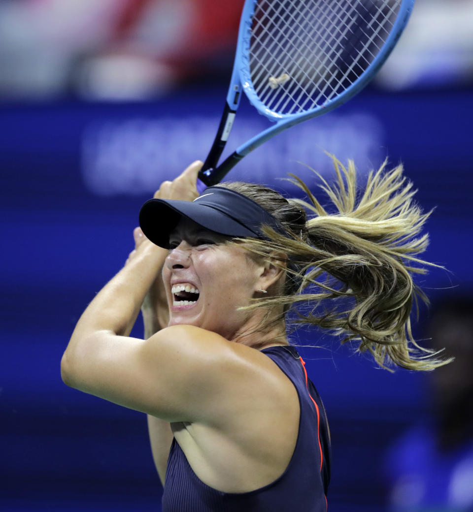 Maria Sharapova returns to Serena Williams during the first round of the U.S. Open tennis tournament in New York, Monday, Aug. 26, 2019. (AP Photo/Charles Krupa)