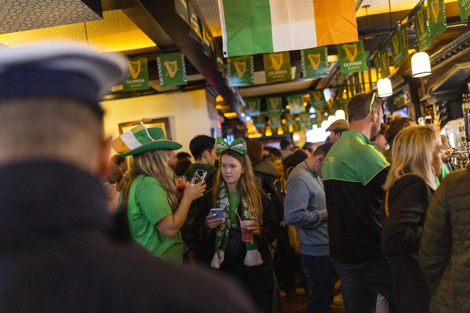 FILE - People enjoy drinks in a local Irish pub during the St. Patrick's Day, Thursday, March 17, 2022, in New York. The day honoring the patron saint of Ireland is a global celebration of Irish heritage. And nowhere is that more so than in the United States, where parades take place in cities around the country and all kinds of foods and drinks are given an emerald hue. (AP Photo/Eduardo Munoz Alvarez, File)