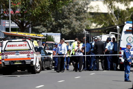 Police and emergency services personnel can be seen behind a road block at the scene of a shooting in the western Sydney suburb of Ingleburn, March 7, 2016. REUTERS/Dan Himbrechts/AAP