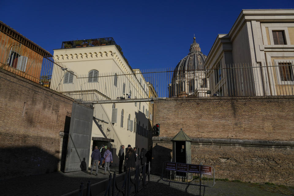 People enter the Vatican, Saturday, Dec. 16, 2023. The once-powerful Cardinal Angelo Becciu and nine other people are to learn their fate Saturday when a Vatican tribunal hands down verdicts in a complicated financial trial that has aired the tiny city state's dirty laundry and tested its justice system. (AP Photo/Andrew Medichini)