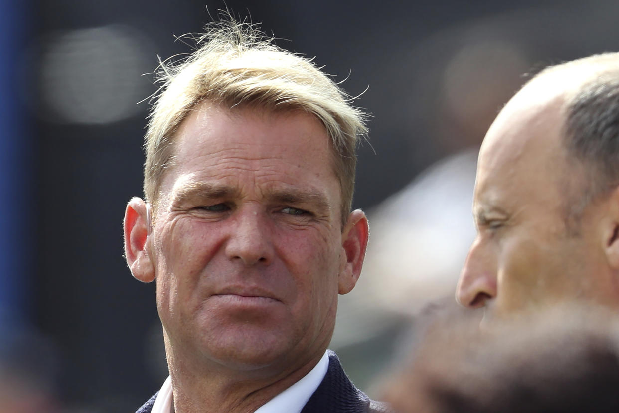FILE - Shane Warne, left, with former England cricket captain Nasser Hussein attends during the Cricket World Cup semi-final match between Australia and England at Edgbaston in Birmingham, England on July 11, 2019. Shane Warne, one of the greatest cricket players in history, has died. He was 52. Fox Sports television, which employed Warne as a commentator, quoted a family statement as saying he died of a suspected heart attack in Koh Samui, Thailand. (AP Photo/Rui Vieira, File)