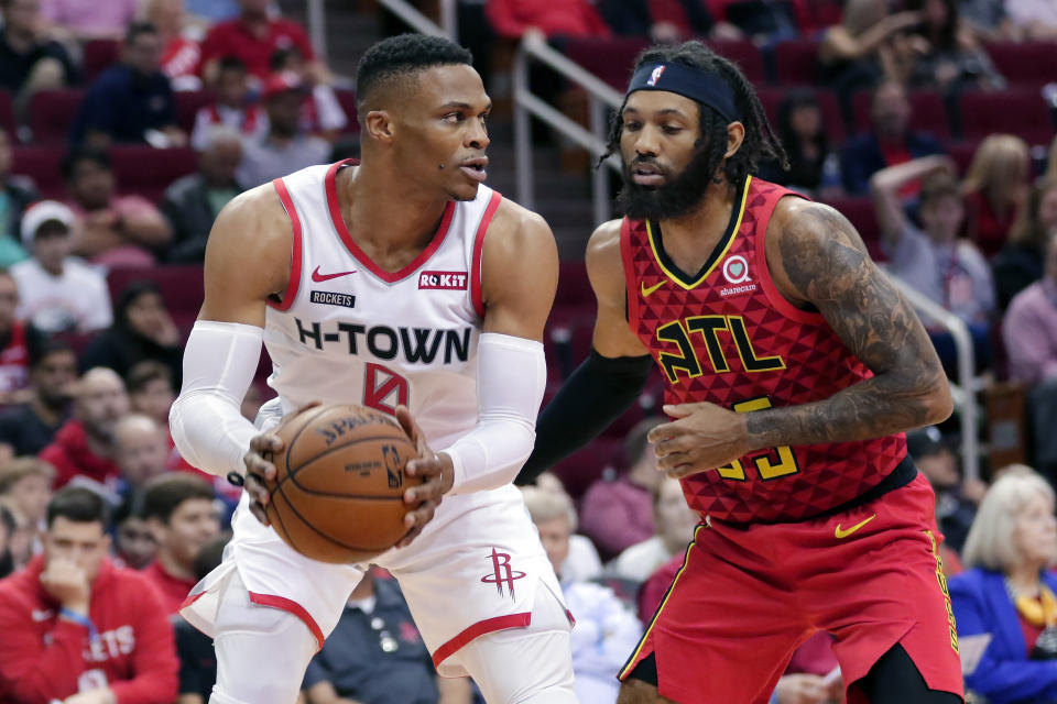 Houston Rockets guard Russell Westbrook (0) looks to pass the ball under pressure from Atlanta Hawks guard DeAndre' Bembry (95) during the first half of an NBA basketball game, Saturday, Nov. 30, 2019, in Houston. (AP Photo/Michael Wyke)