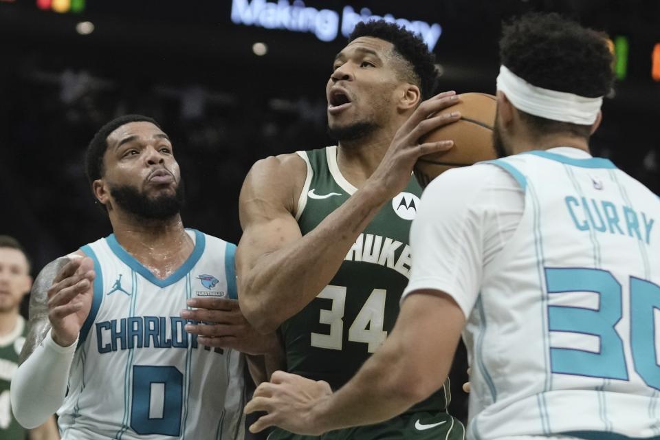 Milwaukee Bucks' Giannis Antetokounmpo drives between Charlotte Hornets' Miles Bridges and Seth Curry during the first half of an NBA basketball game Tuesday, Feb. 27, 2024, in Milwaukee. (AP Photo/Morry Gash)