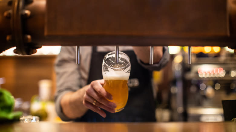 Person pouring a draft beer