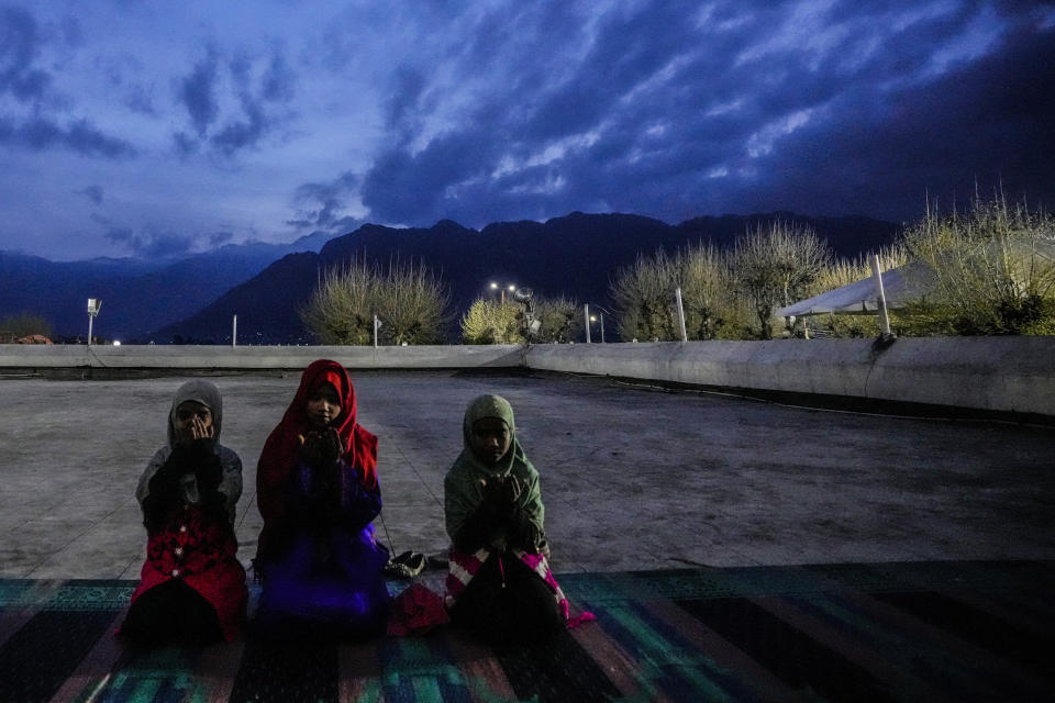 Muslim children offer prayers early morning to observe the martyr day of Hazrat Ali, the fourth caliph of Islam, at Hazratbal shrine in Srinagar, Indian controlled Kashmir, Monday, April 1, 2024. Muslims across the world are observing the holy fasting month of Ramadan, when devout refrain from eating, drinking and smoking from dawn to dusk. (AP Photo/Mukhtar Khan)