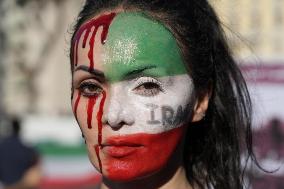 A woman is painted on a her face during a protest against the death of Mahsa Amini, a woman who died while in police custody in Iran, during a rally in central Rome, Saturday, Oct. 29, 2022. (AP Photo/Gregorio Borgia)