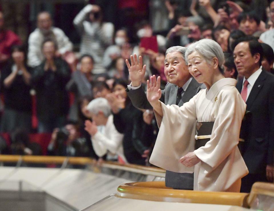 In this Jan. 20, 2019, photo, Japanese Emperor Akihito, front left, and Empress Michiko, front right, acknowledge the crowd during their visit to the New Year Grand Sumo Tournament at Ryogoku Kokugikan in Tokyo. The love many in Japan feel for Akihito was on full display when he made his last official visit to the winter sumo tournament earlier this year. A huge crowd of people leapt to their feet, whooping and grinning as they held up babies and waved flags.(Kyodo News via AP)