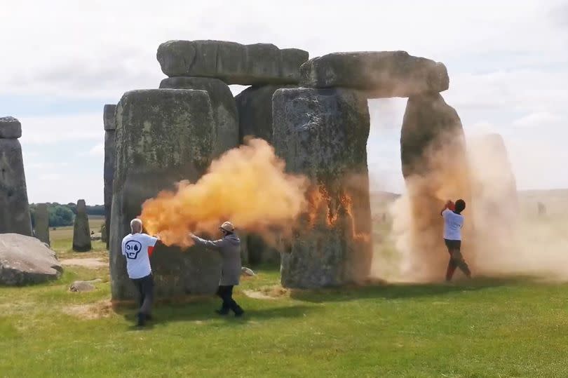 Screen grab taken from handout video of Just Stop Oil protesters spraying an orange substance on Stonehenge