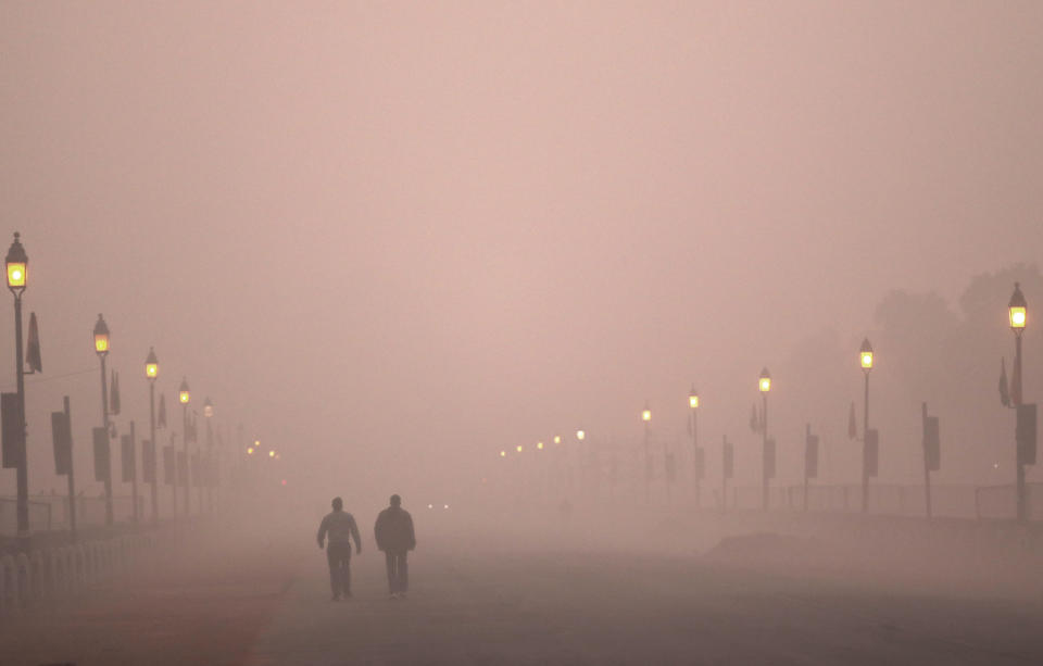 In this Wednesday, Dec. 26, 2018, file photo, people take early morning walk amidst smog in New Delhi, India. Authorities have ordered fire services to sprinkle water from high rise building to settle dust particles and stop burning of garbage and building activity in the Indian capital as the air quality hovered between severe and very poor this week posing a serious health hazard for millions of people. (AP Photo/Manish Swarup, File)