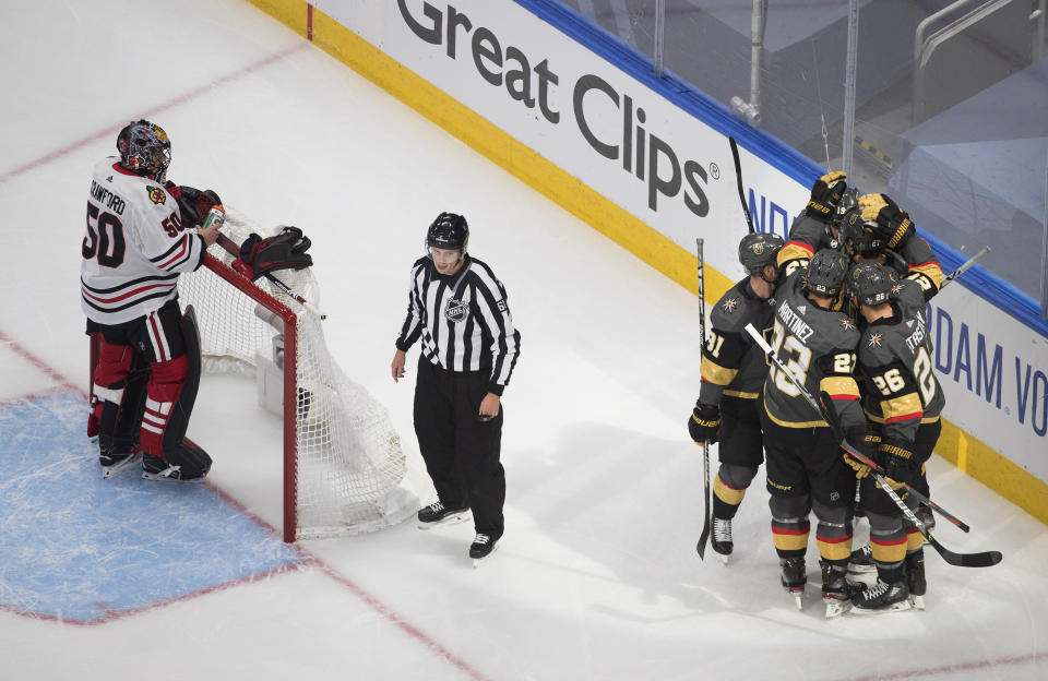 Chicago Blackhawks goalie Corey Crawford (50) waits as the Vegas Golden Knights celebrate a goal during the second period in Game 1 of an NHL hockey Stanley Cup first-round playoff series, Tuesday, Aug. 11, 2020, in Edmonton, Alberta. (Jason Franson/The Canadian Press via AP)