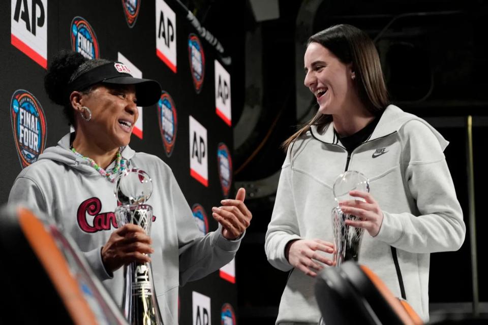 South Carolina head coach Dawn Staley and Iowa’s Caitlin Clark stand together on stage during a news conference announcing the AP NCAA Women’s Coach and Player of the Year in Cleveland.