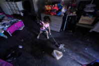 FILE - In this Feb. 23, 2021, file photo, Raella Mills, 3, plays mop-up at her home in Dallas. Raella and her mother's apartment flooded last week by a pipe that burst during the record winter cold. They are still without running water. The snow and ice that crippled some states across the South has melted. But it has exposed the fragility of aging waterworks that experts have been warning about for years. Cities across Texas, Tennessee, Louisiana and Mississippi are still grappling with outages that crippled health care facilities and forced families to wait in line for potable water. (AP Photo/LM Otero, File)