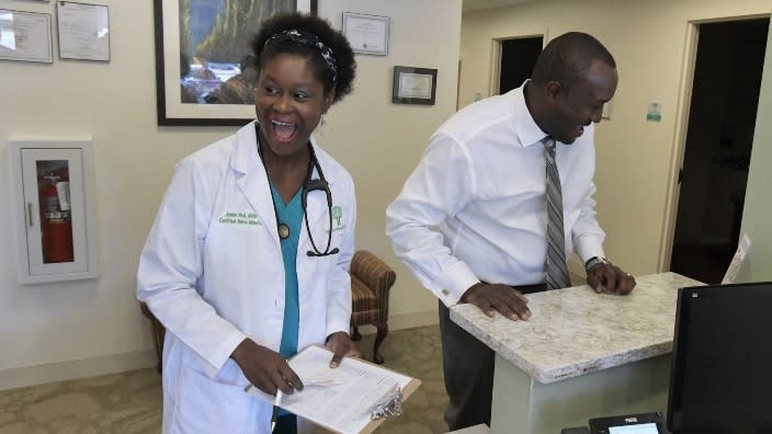 Registered nurse practitioner Jamie Neal (left) shares a light moment between patients with her husband, Derek Neal, the CEO of Life Tree Women Care health center. The couple co-own the practice, the first clinic of its kind in Northeast Florida owned and run by a Black couple, led by a midwife and registered nurse practitioner. (Photo: Bob Self/Florida Times-Union/USA TODAY NETWORK)