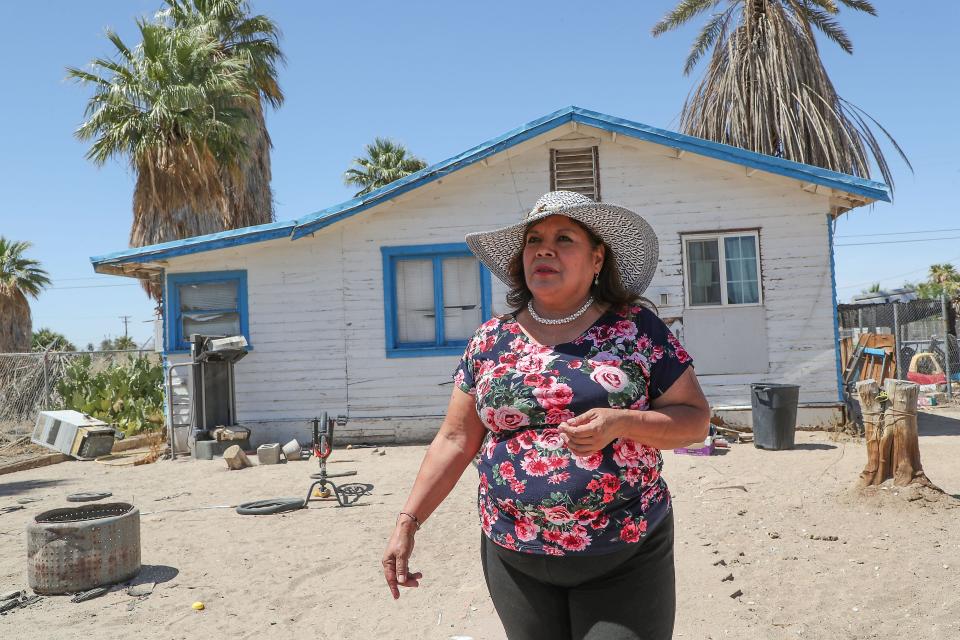 Calipatria, Calif. Mayor Maria Nava-Froelich stands in front of the home where she grew up in Niland, Calif., May 19, 2022. Her parents' rose bushes and other plants are all dead, due to too-high bills from the Golden State Water Co. , she said.