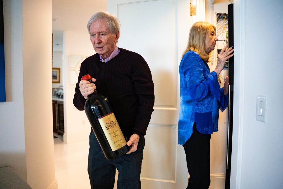 Brian and Denise Cobb pick out some of their favorite wines in their collection at their home in Naples on Thursday, Dec. 21, 2023.