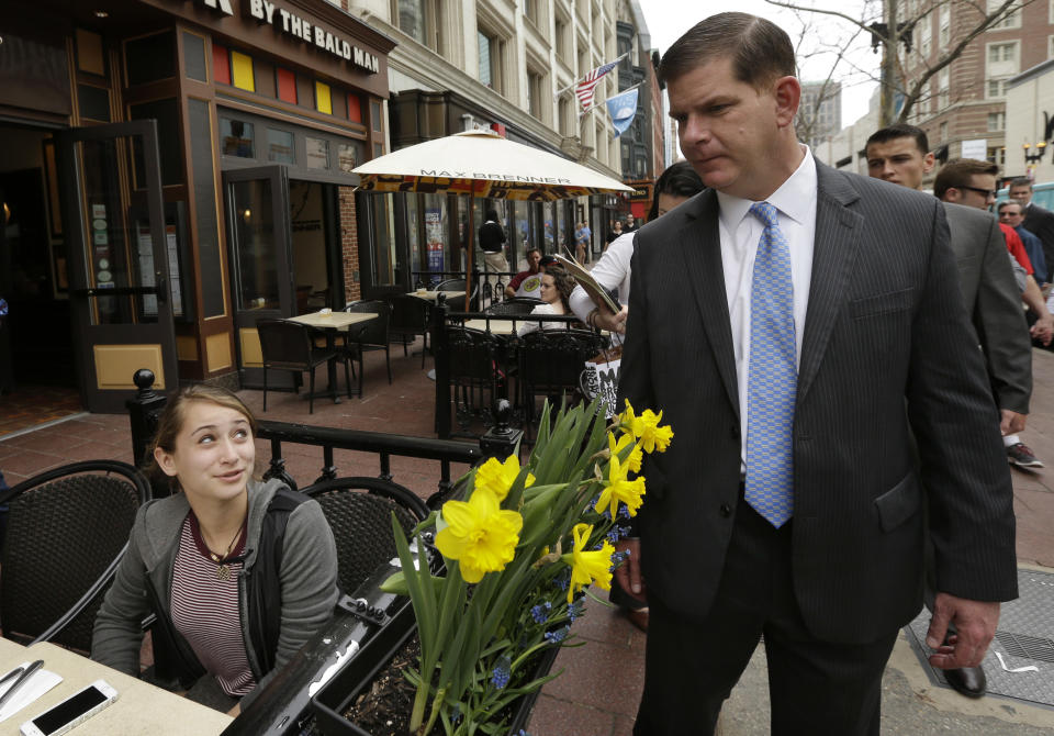 Boston Mayor Marty Walsh, right, chats with Nicole Boggio, of Severna Park, MD, left, at a sidewalk cafe on Boylston Street near the finish line of the Boston Marathon, Monday, April 14, 2014, in Boston. A year after twin pressure cooker bombs shattered the marathon and paralyzed the area for days, federal prosecutors say they have a trove of evidence ready to use against the surviving suspect, but many questions remain. (AP Photo/Steven Senne)