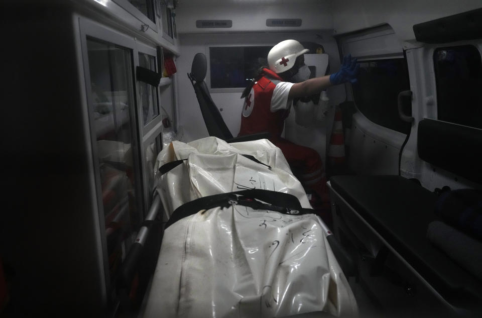 A Lebanese Red Cross volunteer, sits inside an ambulance next a dead body, one of those who were on a boat carrying migrants from Lebanon that sank in Syrian waters, at Arida crossing point between Lebanon and Syria, north Lebanon, Sept. 23, 2022. Syria's health minister says several people have been killed from a boat that sank migrants from Lebanon off Syria's coast. The incident is the deadliest since a surging number of Lebanese, Syrians, and Palestinians have tried to flee crisis-hit Lebanon by sea to Europe. (AP Photo/Bilal Hussein)