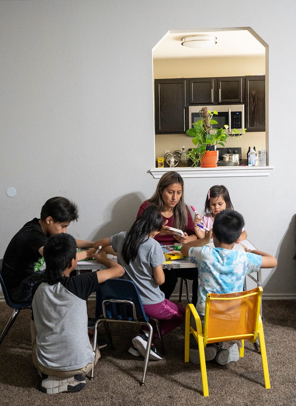 Arlett Mireles, middle, does crafts with her children, from left, Dylan, 10, Dustin, 8, Casey ,7, Dave, 6, and Lindsey, 3, at their home in October. Mireles and her children learned through People's Community Clinic that they had lost Medicaid coverage in August. The clinic has become an even more important health care partner to the family now that they are uninsured.
