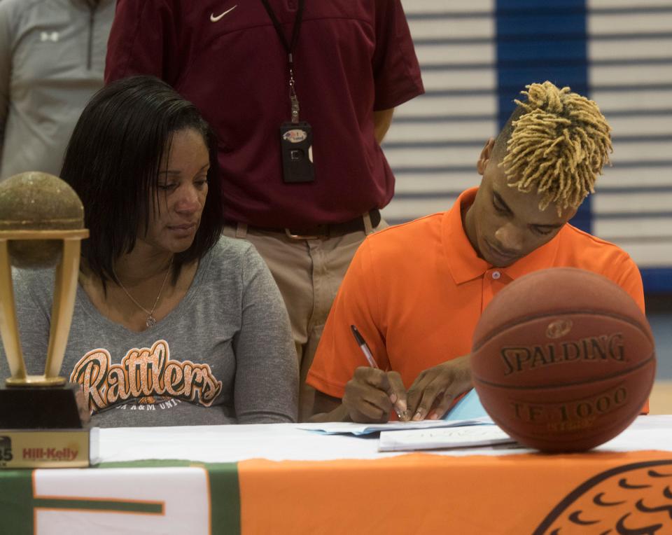 Washington High School basketball standout, Michael Randolph, Jr. signs a letter of intent to continue his basketball career with Florida A&M as his mother look on during a ceremony in the high school gym Wednesday, April 18, 2018. 