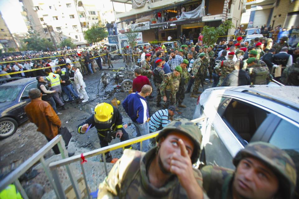 Lebanese army soldiers and civilians gather near the site of an explosion in the Haret Hreik area in the southern suburbs of Beirut