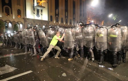 Riot policemen block a protester during a rally against a Russian lawmaker's visit in Tbilisi