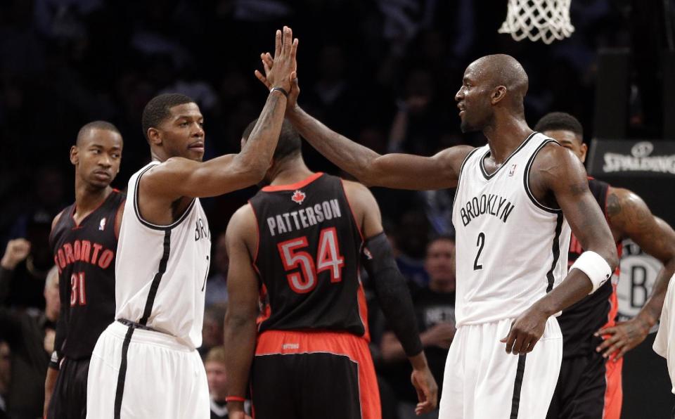 Brooklyn Nets' Kevin Garnett, right, and Joe Johnson celebrate during the first half of Game 3 of an NBA basketball first-round playoff series against the Toronto Raptors on Friday, April 25, 2014, in New York. (AP Photo/Frank Franklin II)