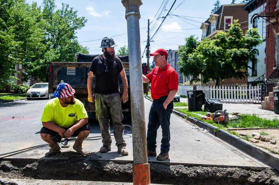 Joe Consorti Jr, left, and Zachary Kellerman, center, from the Consorti Brothers talk with Eric DiLeo from Valenza Plumbing as they discuss how to proceed with a job to replace lead water pipes on Grand Street in the city of Newburgh, NY on Thursday, May 26, 2022. The city is also grappling with how to rid its drinking water supply of harmful 'forever' chemicals like PFOS and PFAS.