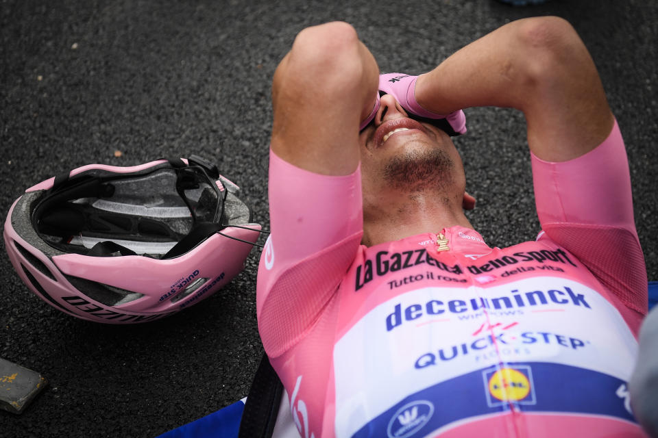 Race leader Portugal's Joao Almeida lies exhausted after concluding the 15th stage of the Giro d'Italia cycling race, from Rivolto to Piancavallo, Italy, Sunday, Oct. 18, 2020. (Massimo Paolone/LaPresse via AP)