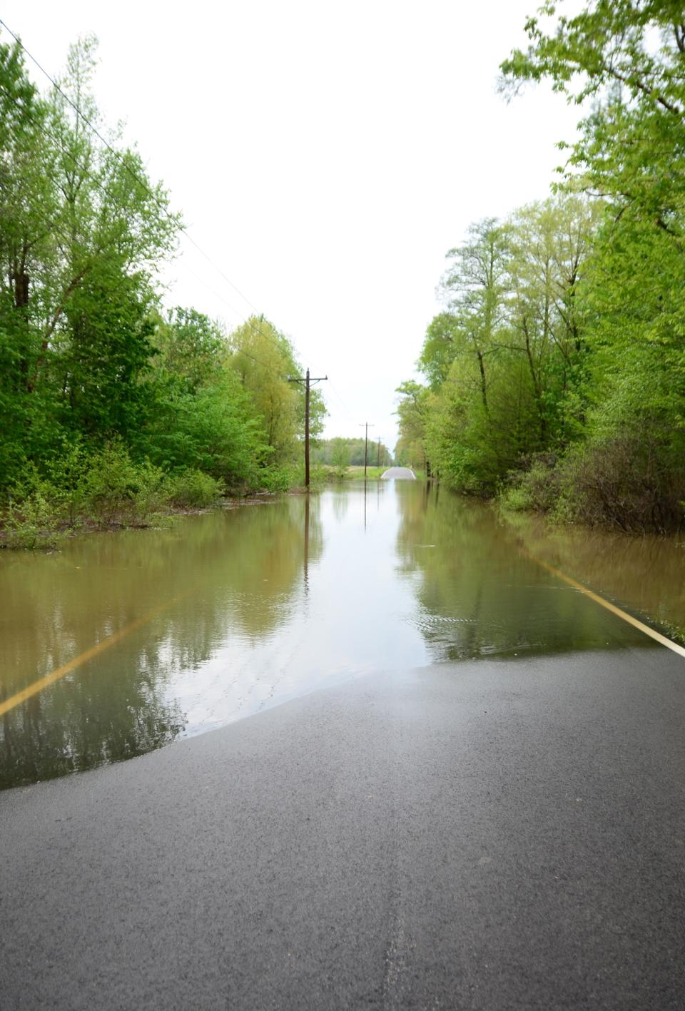 Waters stands across Bonds Road in McCracken County, which is closed at the intersection of Oaks Road due to flooding, Monday, April 28, 2014, in Paducah, Ky. (AP Photo/The Paducah Sun)