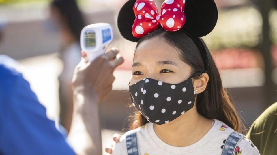 Niña con tapabocas en Disney.