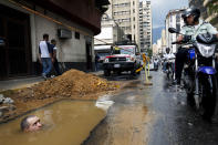 <p>A worker is seen partially submerged under water as he tries to repair a broken pipe in Caracas, Venezuela, Sept. 26, 2012. (Photo: Rodrigo Abd/AP) </p>