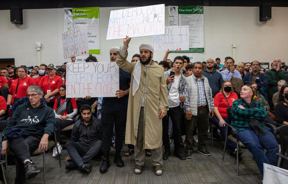 Wadeea Alzabah, 22, a Dearborn resident, holds a sign that reads "If Democracy matters we're the majority," inside the Dearborn Schools Administrative Service Center during the Dearborn Board of Education meeting in Dearborn on Oct. 10, 2022.