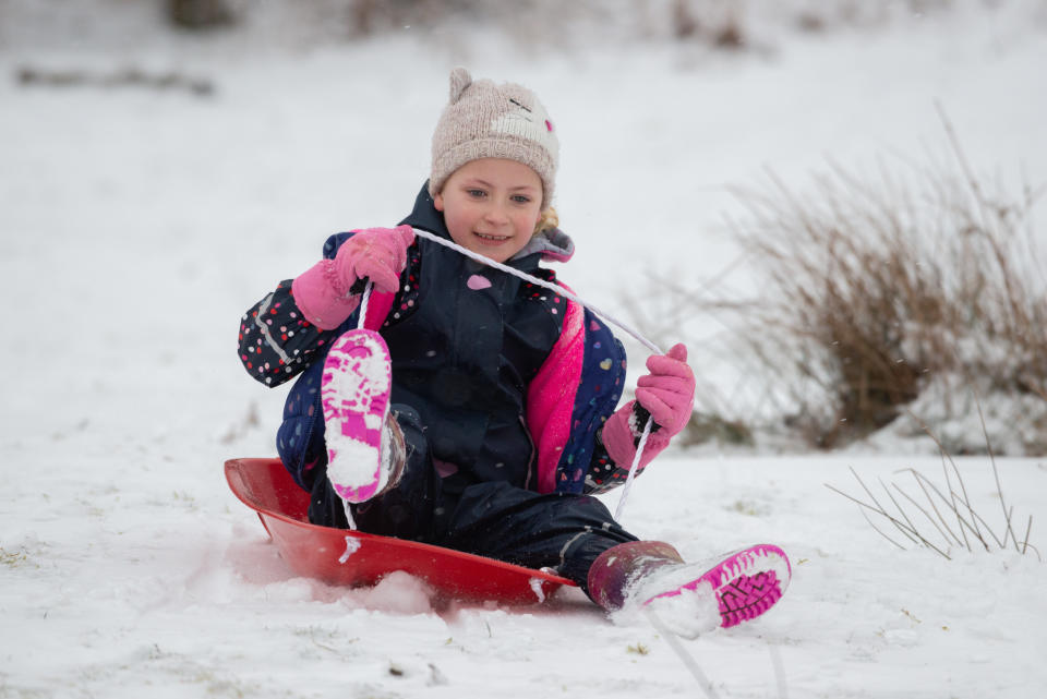 A little girl is pulled along by a sled as the cold snap continues in Sevenoaks, Kent. (SWNS)