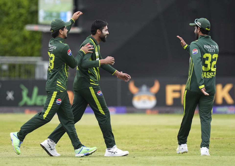 Pakistan's Mohammad Amir, center, celebrates catching out Ireland's George Dockrell with teammates during the third T20 international match between Ireland and Pakistan at the Castle Avenue Cricket Ground, Dublin, Tuesday May 14, 2024. (Niall Carson/PA via AP)