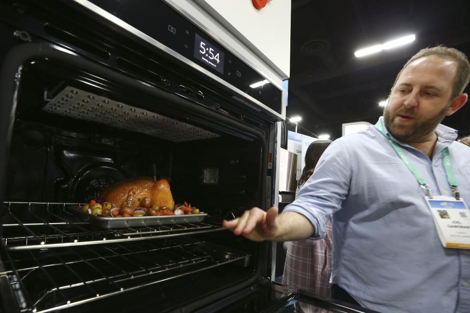 Joel Gamoran, of Yummly, demonstrates the Whirlpool Yummly temperature gauge at the CES Unveiled media preview event, Sunday, Jan. 5, 2020, in Las Vegas. The smart thermometer consists of a probe and a dock, which communicate to each other and to the Yummly mobile app via Bluetooth, monitoring the temperature of the food and the temperature inside the oven. (AP Photo/Ross D. Franklin)