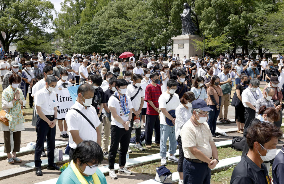 People offer silent prayer for the victims of U.S. atomic bombing at the time when the bomb was dropped, at the Atomic Bomb Hypocenter Park in Nagasaki, southern Japan, Sunday, Aug. 9, 2020. The Japanese city of Nagasaki on Sunday marked its 75th anniversary of the U.S. atomic bombing, with the mayor and dwindling survivors urging world leaders including their own to do more for a nuclear weapons ban. (Takuto Kaneko/Kyodo News via AP)