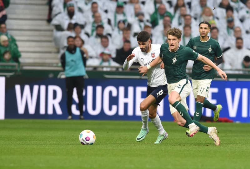 Werder's Jens Stage (R) and Heidenheim's Erin Dinkci battle for the ball during the German Bundesliga soccer match between Werder Bremen and 1. FC Heidenheim at Weser Stadium. Carmen Jaspersen/dpa