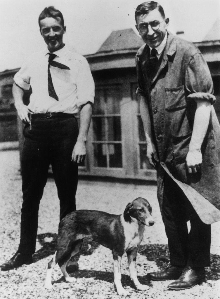 Charles Best (izq) y Frederick Banting (der) con uno de los perros del laboratorio.